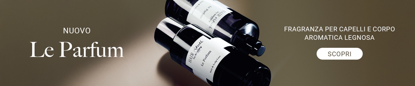 Nuovo Le Parfum fragranza per capelli e corpo aromatica legnosa, flacone nero elegante con testo scopri su sfondo raffinato.